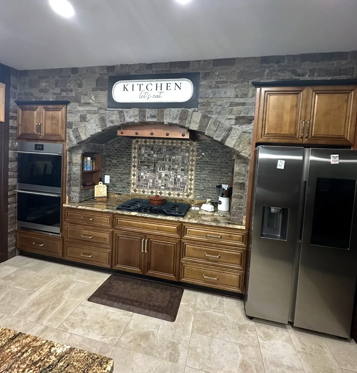Cozy kitchen with wooden cabinets, stainless steel appliances, and a rustic backsplash.